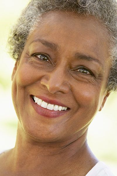 woman smiling with dental implants from Precious Smiles Family Dentistry