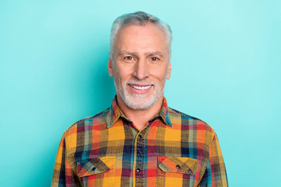 man smiling after getting All-on-X implants