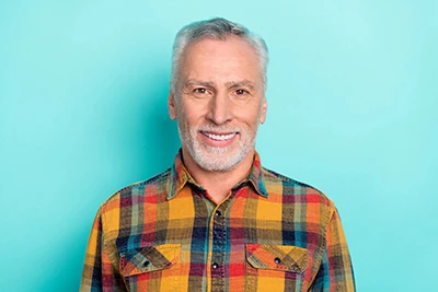 man smiling after getting All-on-X implants
