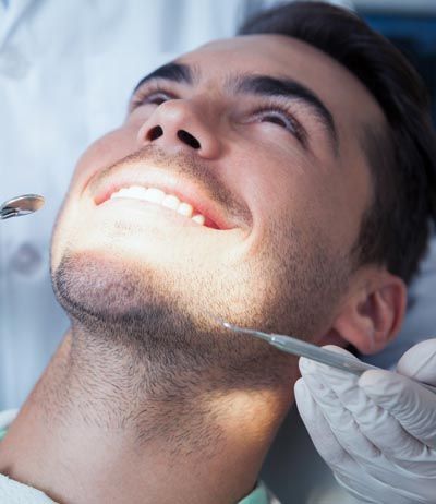man getting checkup after teeth whitening treatment
